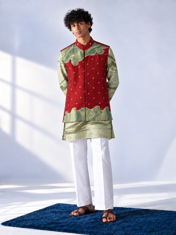  Red sleeveless bandi with gold-tone cutdana bootis and green marbled appliqué panels, worn over a sage and olive marbled kurta.