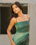 Model wearing teal handwoven bias-draped silk dress with spaghetti straps from Erised’s Gold Line Collection — modern festive luxury look.