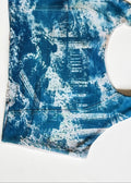 A sleeveless tank top with a blue and white indigo-style tie-dye pattern, laid flat on a white background.
