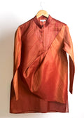 Rust drape kurta with fluid cowl, shade-work ombré and continuous gold zari lines